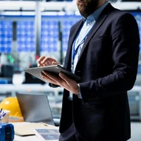 Business professional using a tablet in an office, showing how an Odoo partner Malaysia helps growing businesses scale branches, products, and teams with Odoo ERP.