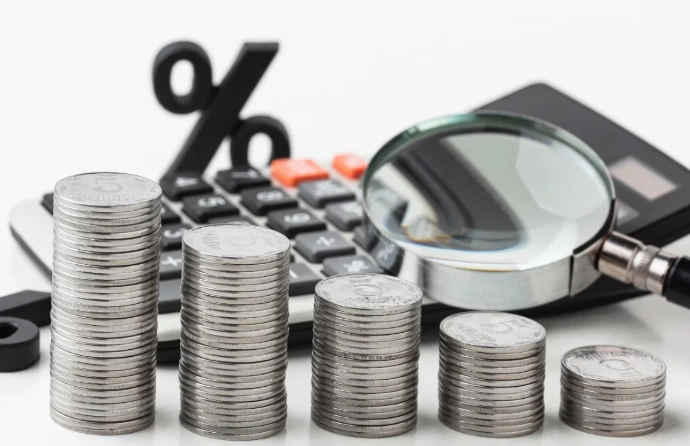 Cost-Effective Odoo Service Provider Malaysia for SMEs Stacks of coins, calculator, and magnifying glass representing cost-effective Odoo Malaysia implementation by a trusted Odoo service provider for SME business growth.